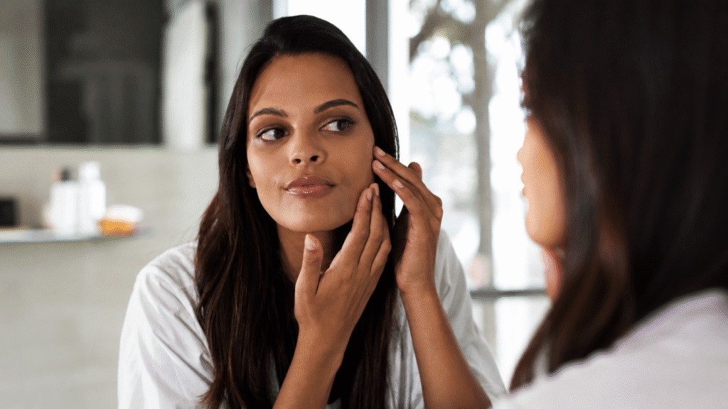 How to Know About Your Skin Type and Why It Matters 1 woman checking her facial skin in the mirror during a skincare routine