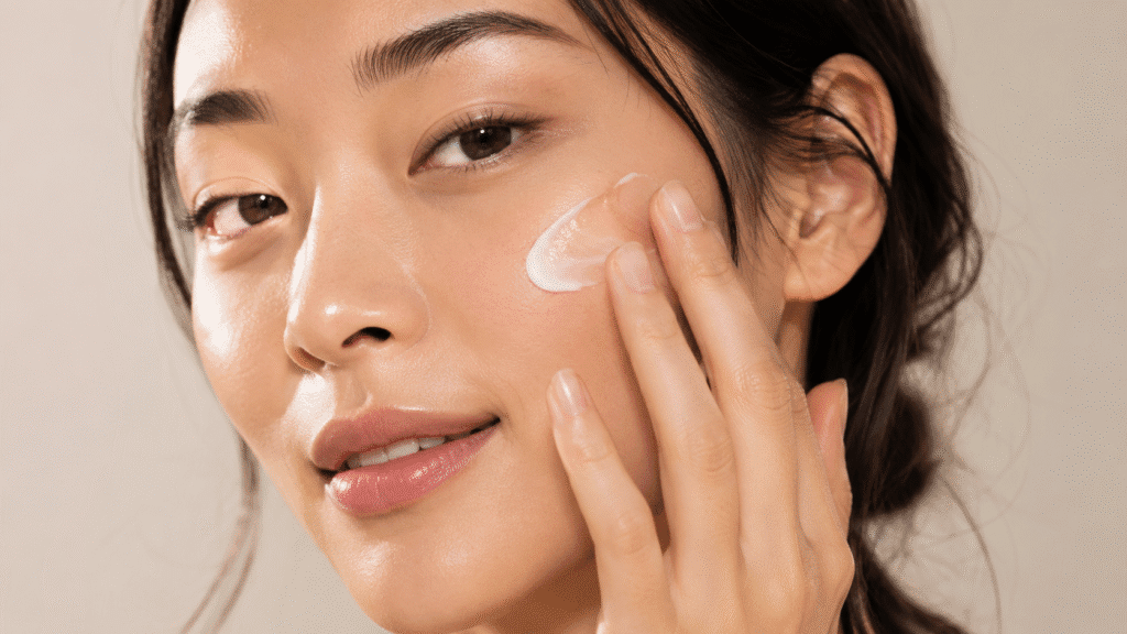 Close up photo of a girl applying moisturizer
