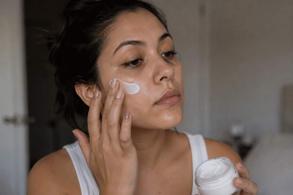 Photo of a woman applying moisturizer to a dirty skin