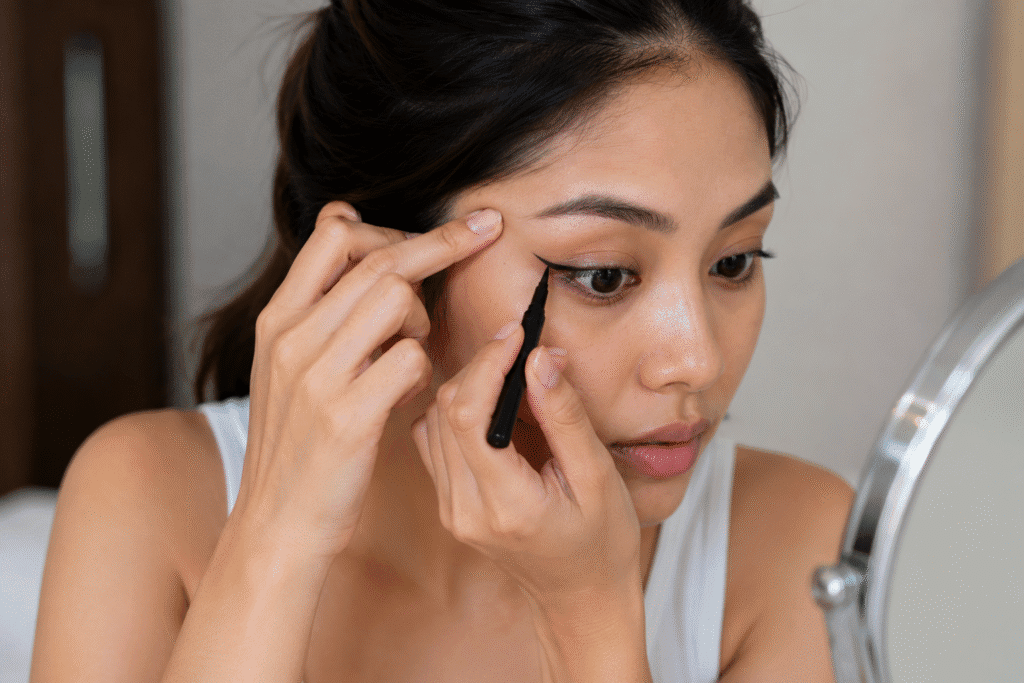 Can Makeup Cause Wrinkles? Truth About Skin Aging 3 Woman tugging her skin while applying makeup
